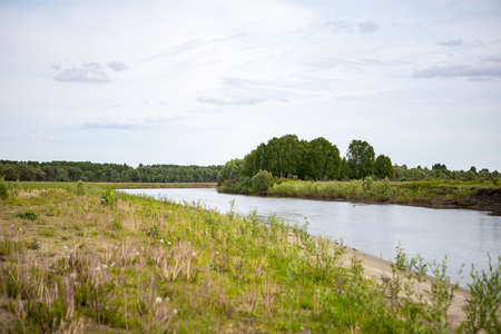 View of the Tara river, Omsk region, Siberia, Russia. Surroundings of the Siberian expanses. Picturesque view on the steep Bank of the river.の写真素材