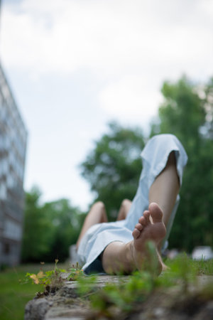 women's feet. The girl is lying on a concrete fence with her bare feet stretched out. Women's feet...