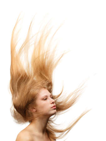 Young beautiful woman with long blond hair flowing like a flame isolated on white backgroundの写真素材