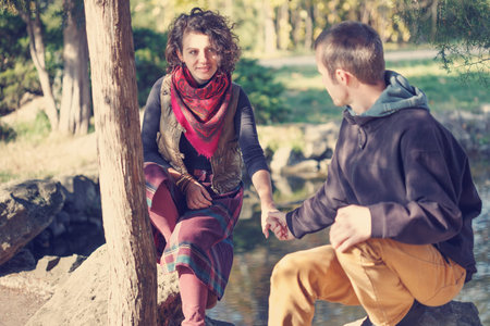 Loving couple in bright clothes meeting in the park near the lake