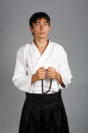 Man in kimono with prayer beads isolated on grey background.の写真素材