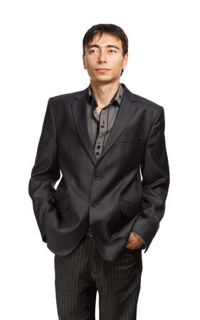 Young businessman in dark grey coat and steel-blue shirt standing isolated on white backgroundの写真素材