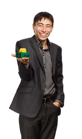 Young businessman in dark grey coat and steel-blue shirt standing isolated on white background with giftの写真素材