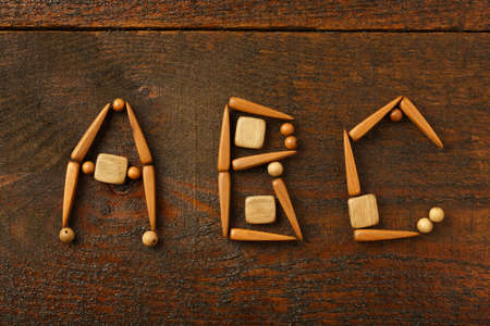 Beautiful creative design of alphabet letters from the wooden parts in ethnic style on brown tableの写真素材