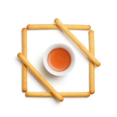 Minimalistic food design with cup of red chinese tea and biscuit cookie sticks isolated on white...