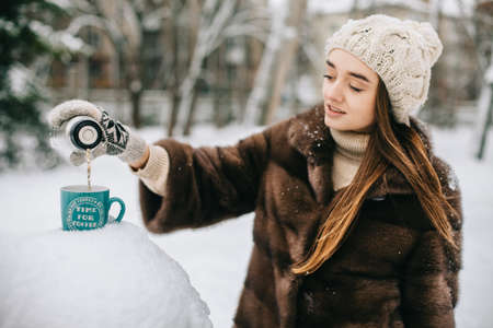woman hands pours hot tea or coffeeの写真素材