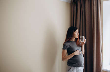 Young pregnant woman drinking waterの写真素材