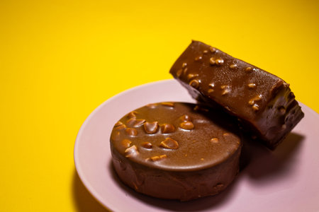 Chocolate tart on a pink plate. Yellow background, top view