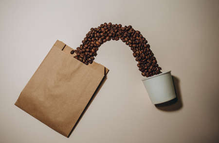 Two disposable craft glasses with package, gift box and coffee beans on craft background . Monochrome photo copy spaceの写真素材