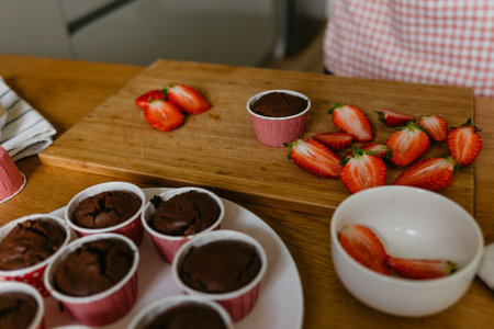 Woman prepares muffins decorated with fresh fruits. Healthy snack. Step by step tutorial.の写真素材