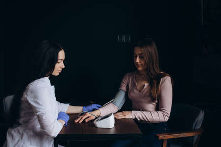 Portrait of confident practitioner measuring blood pressure of patientの写真素材