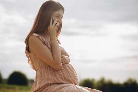 Caucasian pregnant woman talking on the smart phone.の写真素材