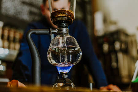 brewing coffee siphon. step by step cooking instructions. coffee is ready. Barista pouring brewed coffee in the cupの写真素材