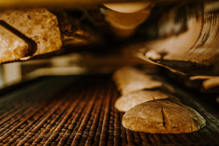 Fresh buns from the oven. Conveyor with bread. Baking bread. Workshop for production of bread. White bread in the oven. hot buns. confectionery.の写真素材