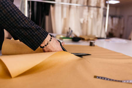 Hand scissor fabric. cutting fabric closeup. tailor at work.の写真素材