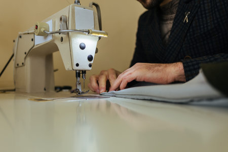 pattern, scissors, tape measure, and a sewing machine. Workplace of seamstress. Dressmaker cuts...