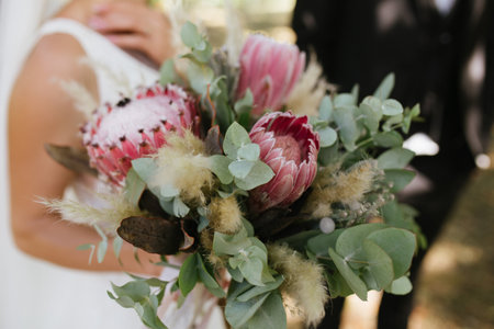 Beautiful white wedding bouquet with bride sitting in the background - shallow dofの写真素材