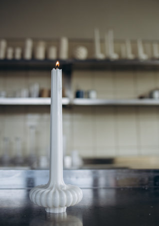 DIY wax candle making process. Woman making decorative wax candle and decorates with dried flowers, close-up of handsの写真素材