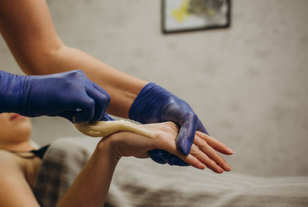 Waxing. Depilation hand and arm of the young woman lying in the spa salonの写真素材