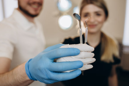 Close up of dentist's hands holding dental tools.