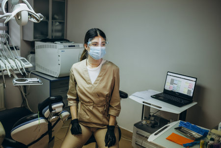 Portrait of a female dentist. She is sitting on a chair in her dentist's office. copy spaceの写真素材