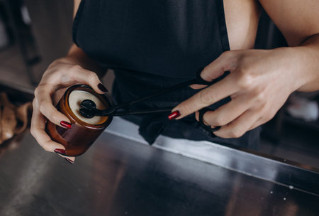 Woman making decorative aroma candle at table, closeup.