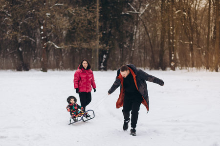 A married couple with their daughter is walking through the winter forest.の写真素材