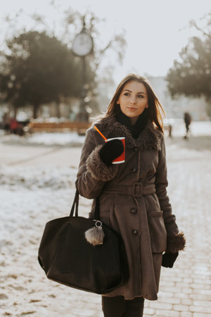 Closeup portrait of a young beautiful lady walking at the street of the old city. Model wearing stylish black fur coat and wide-brimmed hat. girl looking side. female fashion concept. tonedの写真素材