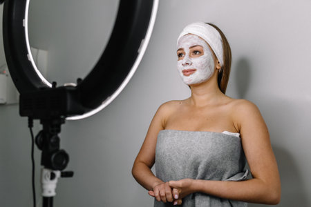 Attractive talented female blogger reviews beauty product for video blog, gives advice to girls and women, films process on camera.の写真素材