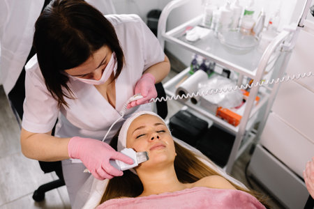 Woman receiving cleansing therapy with a professional ultrasonic equipment in cosmetology officeの写真素材
