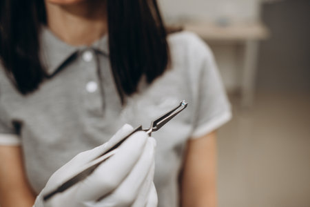 the orthodontist takes the button for braces with forcepsの写真素材