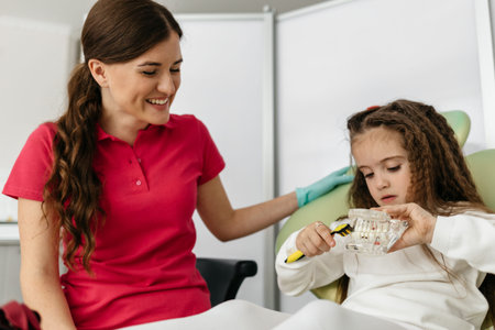 Dentist teaching girl how to brush teeth