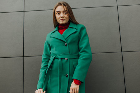 Beautiful fashion model in autumn green clothes on background. Sexy lady in elegant coat.の写真素材