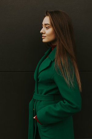 Beautiful fashion model in autumn green clothes on background. Sexy lady in elegant coat.の写真素材