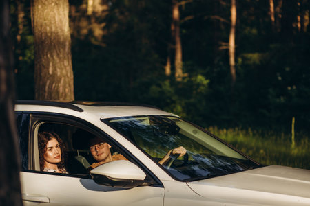 road trip, travel, dating, couple and people concept - happy man and woman driving in cabriolet car outdoorsの写真素材