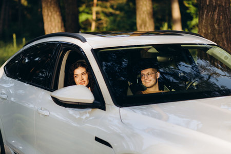 road trip, travel, dating, couple and people concept - happy man and woman driving in cabriolet car outdoorsの写真素材