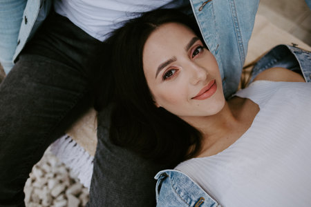 Young beautiful pregnant woman sitting on windowsill at homeの写真素材