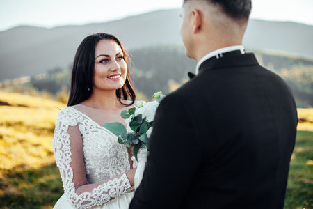 Sunshine portrait of happy bride and groom outdoor in nature location at sunset. warm summer timeの写真素材