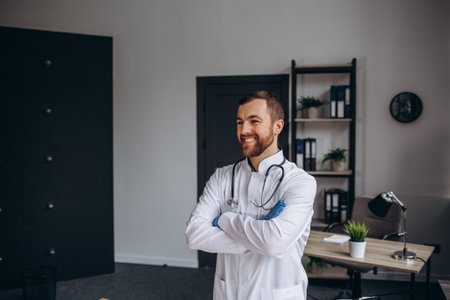 Portrait of mature male veterinarian smiling at camera while sitting on examination tableの写真素材