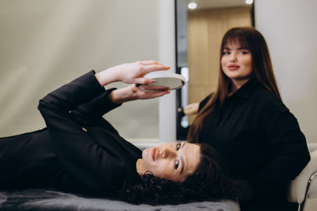 Permanent make-up for eyebrows of beautiful young woman in beauty salon.の写真素材