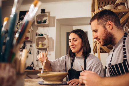 A happy young couple paints dishes at a pottery classの写真素材