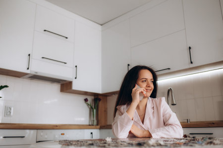 Happy overjoyed woman with smartphone getting unbelievable good news from message on mobile phone while working at laptop from home, making yes winner hand gesture, celebrating job achieve, successの写真素材