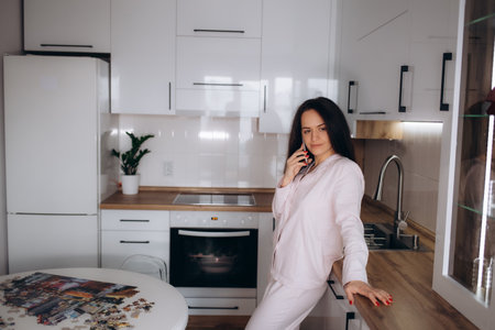 Happy overjoyed woman with smartphone getting unbelievable good news from message on mobile phone while working at laptop from home, making yes winner hand gesture, celebrating job achieve, successの写真素材