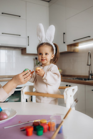 a little cute girl paints Easter eggs. spring flowers hyacinths, colorful eggs - holiday decoration.の写真素材