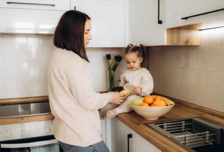Healthy food at home. Happy family in the kitchen. Mother and child daughter are preparing the vegetables and fruit.の写真素材