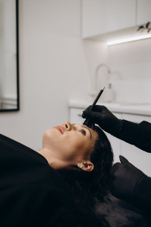 Permanent makeup on eyebrows by professional cosmetologist.の写真素材