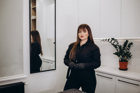 Master teacher in permanent makeup. Permanent makeup artist a tattoo machine in his hand. Beauty industry business lady. Portrel of the permanent makeup trainer. insulationの写真素材