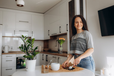 Caucasian young woman doing some gardening at home with her colorful plantsの写真素材