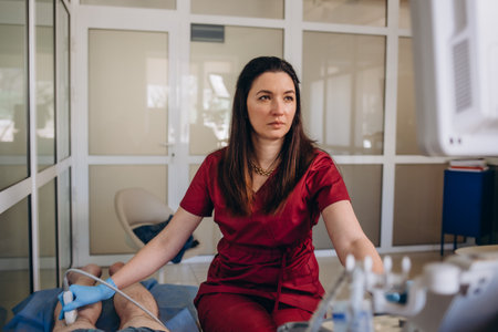 Orthopedist doctor doing ultrasound examination of patient's leg veins in his office. Young woman passing ultrasound scan in clinic. doctor work. medical research.の写真素材