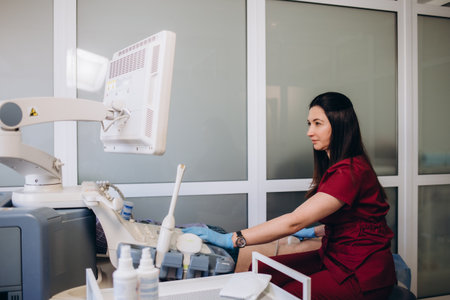 Doctor conducting ultrasound examination of patient's knee in clinicの写真素材